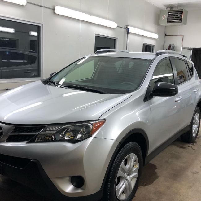 A silver SUV, freshly detailed, inside the Total Recon shop.