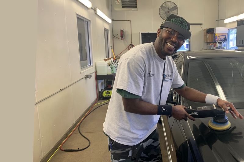 Picasso, owner of Total Recon, machine-polishing a car in the shop.